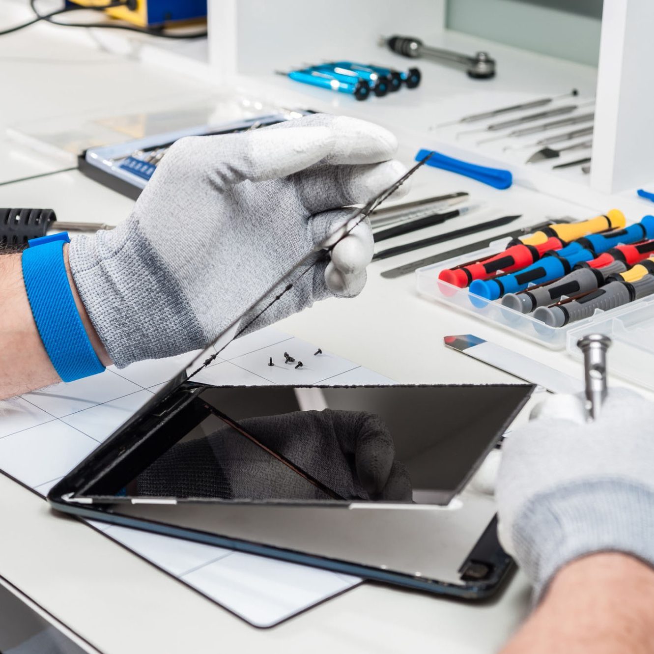 dreamstime_m_53224838 Tablet, pod repair. Technician hands repairing a used tablet, pod with broken screen